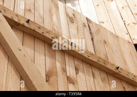 Parte dei cancelli in legno collegati da tavole con chiodi metallici Foto Stock