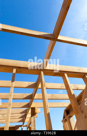 Robusto legno casa costruzione di edificio di legno e materiali di costruzione di una casa del telaio contro il cielo blu Foto Stock
