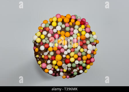 Immagine macro di un 'freckle', cioccolato bud rivestito in spruzzino, isolata su uno sfondo grigio Foto Stock
