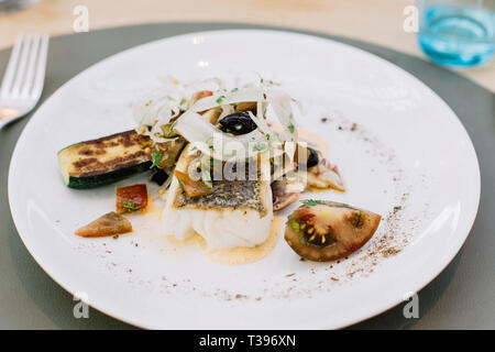 Piatto di pesce arrosto con cimelio di pomodori, zucchine, le cipolle e le erbe fresche in un ristorante a Amsterdam, Paesi Bassi Foto Stock