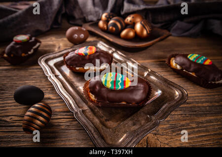 Eclairs con glassa al cioccolato e decorazione di Pasqua Foto Stock