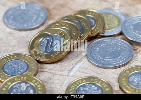 Zloty polacco monete giacente su un vecchio superficie in legno closeup Foto Stock