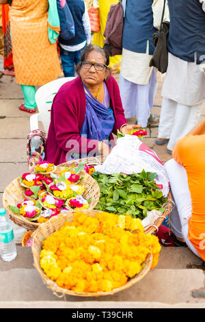 Varanasi. India, Mar 10 2019 - Una donna indiana vendita candele floreali di galleggiare come offerta sul fiume santo Gange a Varanasi in Uttar Pradesh Foto Stock