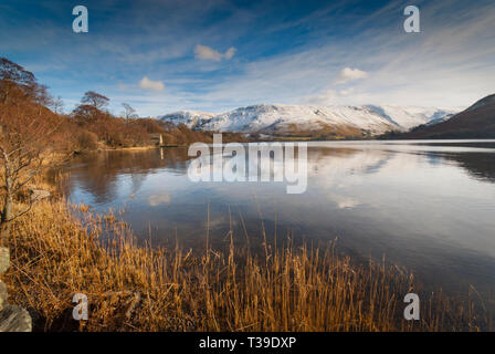 Guardando ad ovest attraverso Ullswater per la coperta di neve fells su un bel giorno inverni nel Lake District cumbria. Foto Stock