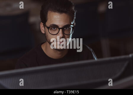 Vista di una schermata del volto di un giovane computer science student a lavorare con il computer. Foto Stock