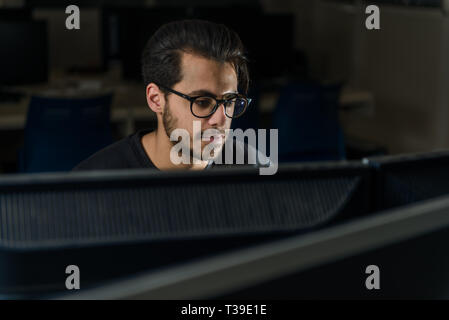 Vista di una schermata del volto di un giovane computer science student a lavorare con il computer. Foto Stock