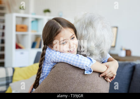 Bambina abbracciando la nonna Foto Stock