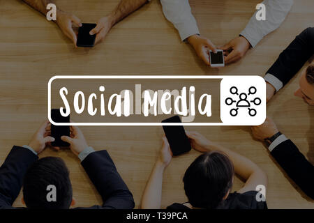 Un gruppo di uomini di affari che mettendo le mani insieme sulla scrivania con piena di documenti di analisi - Social Media parola Foto Stock