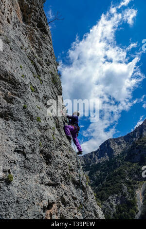 Rocciatore sulle ripide scogliere con montagne, Lagada, Peleponnese, Grecia Foto Stock