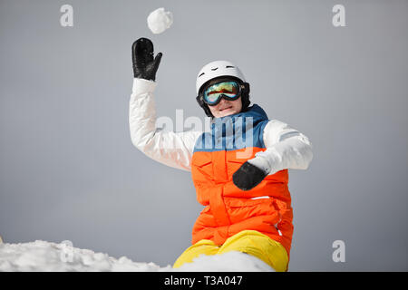 Giovane donna snowboarder giocando con la neve Foto Stock