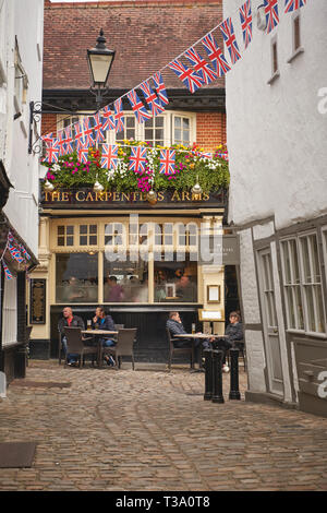 Windsor, Regno Unito - dicembre, 2018. Persone di bere al di fuori di un villaggio tipico pub vicino al Castello di Windsor. Foto Stock