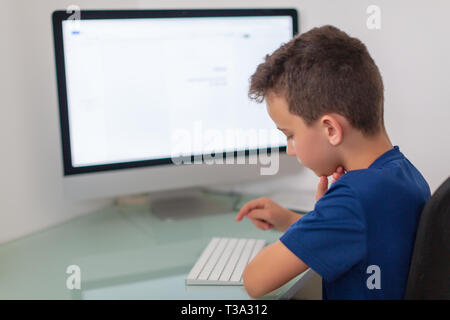 New Media Education, kid watching Lezioni di apprendimento su pc. Classe virtuale Foto Stock