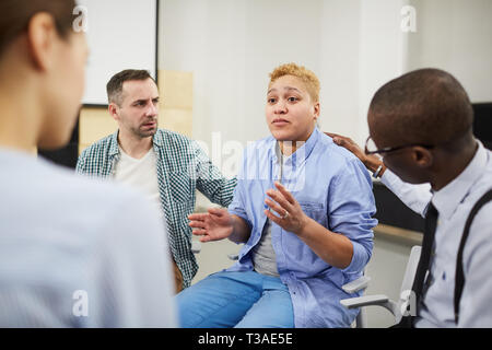 Lottando donna la condivisione nel gruppo di assistenza Foto Stock