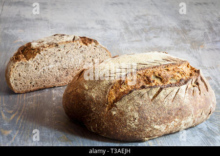 Due polpettine (o miche) della pasta madre francese, chiamato come pure Pain de campagne a visualizzare su di un tavolo di legno. Pain de Campagne è un tipico francese enorme Foto Stock