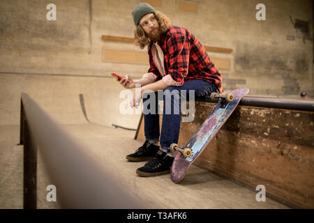 Skater Smartphone di contenimento Foto Stock