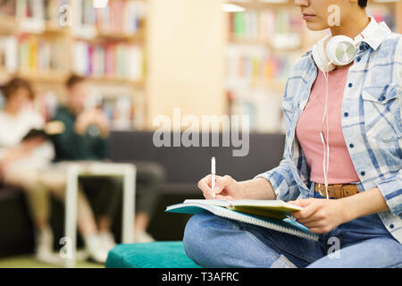 Studenti impegnati rendendo note nella cartella di lavoro Foto Stock