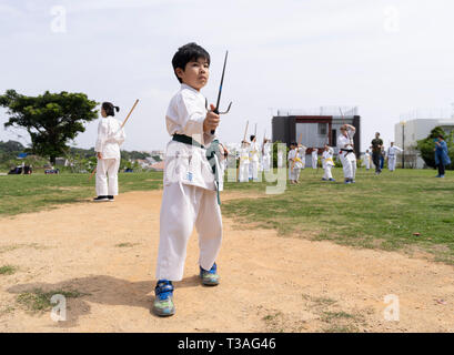 I bambini di Okinawa prendendo parte al 100 Kobudo Kata Challenge 2019 a Sakiyama Park, Shuri, Okinawa il 31 marzo 2019. Foto Stock