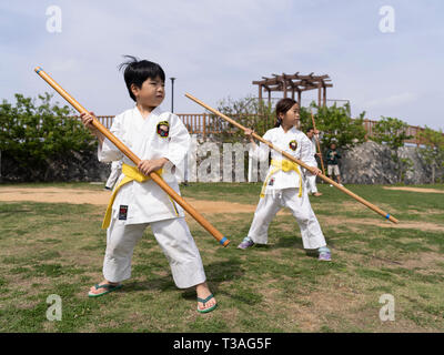 I bambini di Okinawa prendendo parte al 100 Kobudo Kata Challenge 2019 a Sakiyama Park, Shuri, Okinawa il 31 marzo 2019. Foto Stock