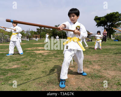 I bambini di Okinawa prendendo parte al 100 Kobudo Kata Challenge 2019 a Sakiyama Park, Shuri, Okinawa il 31 marzo 2019. Foto Stock