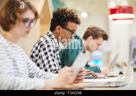Occupato gli studenti in classe computer Foto Stock