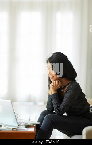 Donna guardando film sul computer portatile Foto Stock