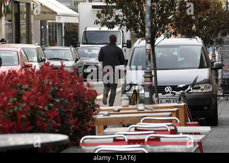 Karlsruhe, Germania. 02Apr, 2019. Nel sud Waldstrasse una persona cammina lungo la strada. Sulla sinistra ci sono le vetture su una striscia di parcheggio. Sulla destra è una macchina parcheggiata in un non ufficiale di parcheggio. Sarà stretto in Germania il marciapiedi. Ora coloro che appartengono vi lotta indietro: pedoni. (A dpa " lotta per il marciapiede: pedoni difendersi contro ostacolo corso') Credito: Uli Deck/dpa/Alamy Live News Foto Stock