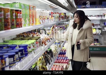 (190408) -- CHONGQING, 8 aprile 2019 (Xinhua) -- una donna sceglie le merci importate a Chongqing International Exhibition & Trading Center di Chongqing, a sud-ovest della Cina, Gennaio 18, 2019. Il russo gelato. Vino georgiano. Pelle italiana. Decorazioni del Kenya. Prodotti stranieri sono diventati un colpo nel sud-ovest della Cina come la cinghia e iniziativa su strada guadagna ulteriore vapore. Nella Municipalità di Chongqing, un legato di centro di scambi commerciali circa 10 km dal centro della città ha attirato innumerevoli singoli e di gruppo ai clienti sperando di acquistare l'ambita ma a buon mercato estera merci trasportate in Cina di merci Foto Stock