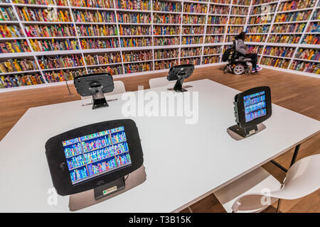 Londra, Regno Unito. 08 apr, 2019. La British Library un'installazione di Yinka Shonibare CBE (nella foto con il suo lavoro), alla Tate Modern, è appena stata acquisita da loro. Evidenziando l'impatto dell'immigrazione sulla cultura britannica, è un sito-specifica installazione con una piattaforma digitale per i visitatori a partecipare alla discussione.it contiene 6,328 libri rilegati in "dutch stampa di cera. L'installazione contiene anche un'area per il pubblico di accedere alle informazioni circa il progetto su compresse. Credito: Guy Bell/Alamy Live News Foto Stock