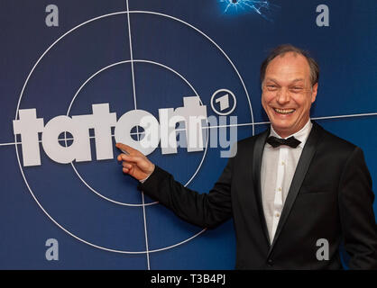 Dresden, Germania. 08 apr, 2019. Martin Brambach, attore, sorge prima dell'inizio dell'anteprima di MDR della scena del crimine 'Dcome Nest" di fronte a un muro di pubblicità in Cineplex Rundkino Dresden. La scena del crimine è quello di essere trasmesso su ARD il 28 aprile a 8.15 pm. Credito: Robert Michael/dpa-Zentralbild/dpa/Alamy Live News Foto Stock