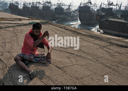 I pescatori di pesce di riparazione net presso il porto, Chittagong, Divisione di Chittagong, Bangladesh Foto Stock