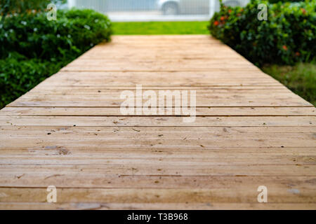 Tavole di legno sono disposti in fila, ad essere passerella, nel giardino. Foto Stock