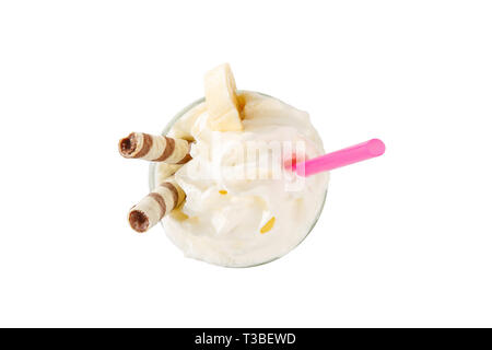 Cocktail di latte con condotto di wafer, rosa paglia, isolato sfondo bianco in un bicchiere alto e panna montata con banana, vaniglia, vista da sopra Foto Stock