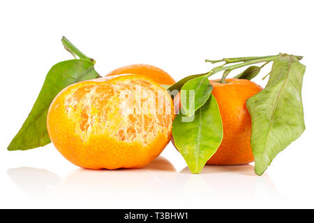 Gruppo di tre intere fresche arancione mandarine con foglie verdi un frutto è metà pelato isolati su sfondo bianco Foto Stock