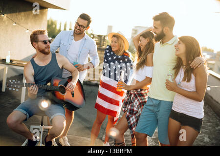 Gruppo di amici felice avente parte sul tetto Foto Stock