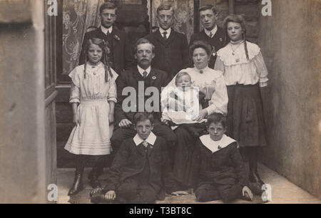 Vintage Cartolina fotografica che mostra un Edwardian famiglia, un padre ed una madre con i loro otto figli. Foto Stock