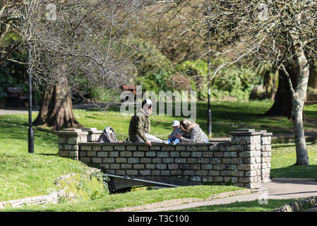 Una famiglia godendo il sole primaverile in Trenance Gardens a Newquay in Cornovaglia. Foto Stock