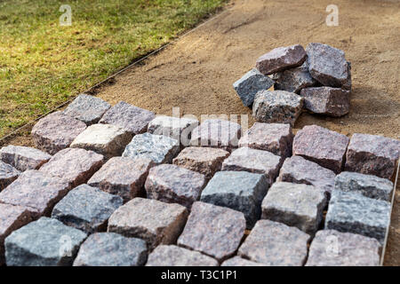 Giardino di costruzione del percorso - posa di pietra in granito lastricatori a casa cortile Foto Stock