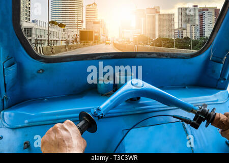 La guida blu di triciclo di tuk-tuk alla luce solare città urbana sfondo Foto Stock