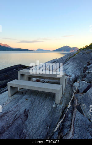 Un tavolo da picnic al Hellåga area riposo su Sjonafjord lungo la nazionale Helgelandskysten percorso panoramico nel Nordland Norvegia - crepuscolo paesaggio del fiordo Foto Stock