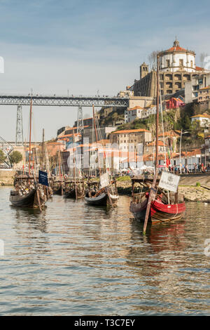 Barche tradizionali utilizzati per trasportare il prezioso carico di barili di porto giù il fiume Douro, a Porto, Portogallo Foto Stock