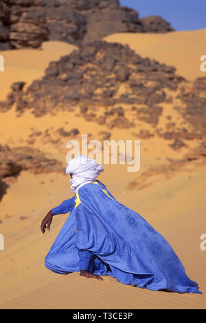 Touareg seduto su una duna nel deserto del Sahara, Algeria Foto Stock