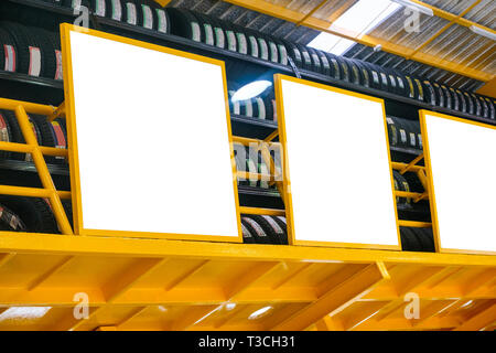 Bianco tabellone vuoto con pneumatici ordinati nel garage di colore giallo Foto Stock
