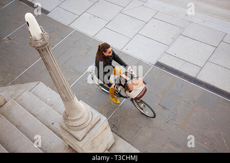 Donna in bicicletta nella città di Lubiana, Slovenia Foto Stock