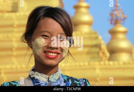 MANDALAY, MYANMAR - Dicembre 17. 2015: Ritratto di una ragazza birmano con tradizionale Thanaka volto dipinto nella parte anteriore del golden Pagoda Kuthodaw al tempio Foto Stock