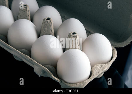 Di uova fresche in confezione aperta su sfondo nero Foto Stock