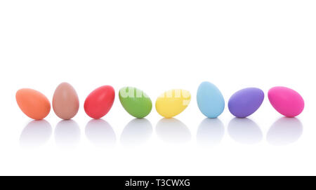 Luminose e colorate uova di Pasqua in fila, isolato su uno sfondo bianco Foto Stock