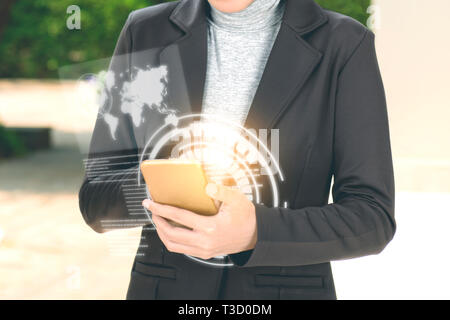 Business donna utilizzando il telefono cellulare sulla sua mano con schermo virtuale che visualizza l'interfaccia di mappe del mondo e codice binario. La tecnologia digitale concep Foto Stock