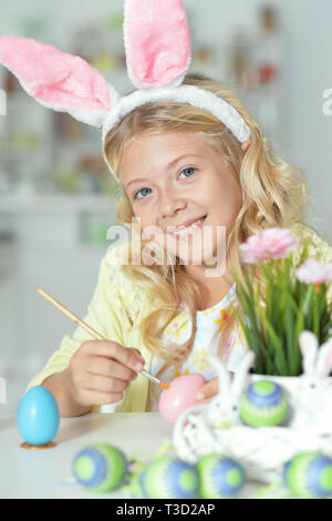 Bambina dipingere le uova per vacanze di Pasqua Foto Stock