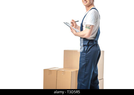 Vista ritagliata della mover in scrittura uniforme negli appunti vicino a scatole di cartone isolato su bianco con spazio di copia Foto Stock