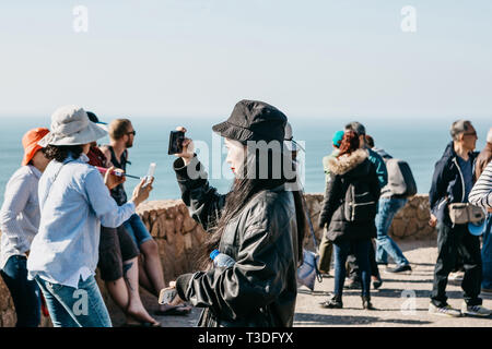 Il Portogallo, Sintra, 26 Giugno 2018: una ragazza asiatica prende le immagini di una bellissima vista del capo Roca su una soleggiata giornata estiva. Nelle vicinanze ci sono altri turisti. Foto Stock